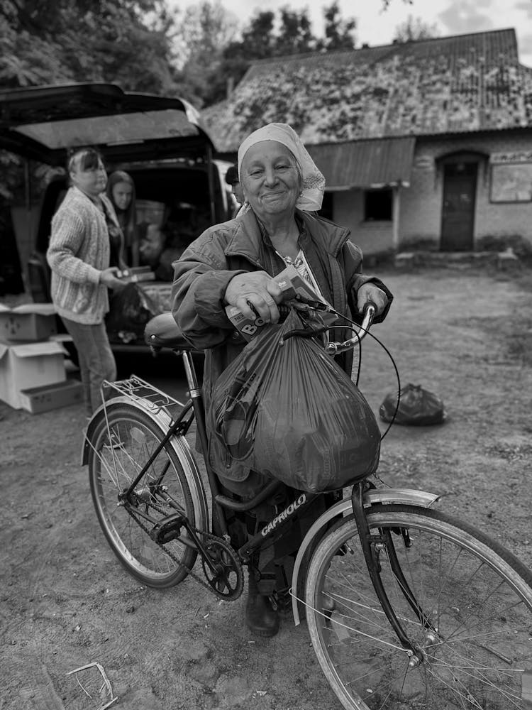 Elderly Woman Pushing A Bicycle 