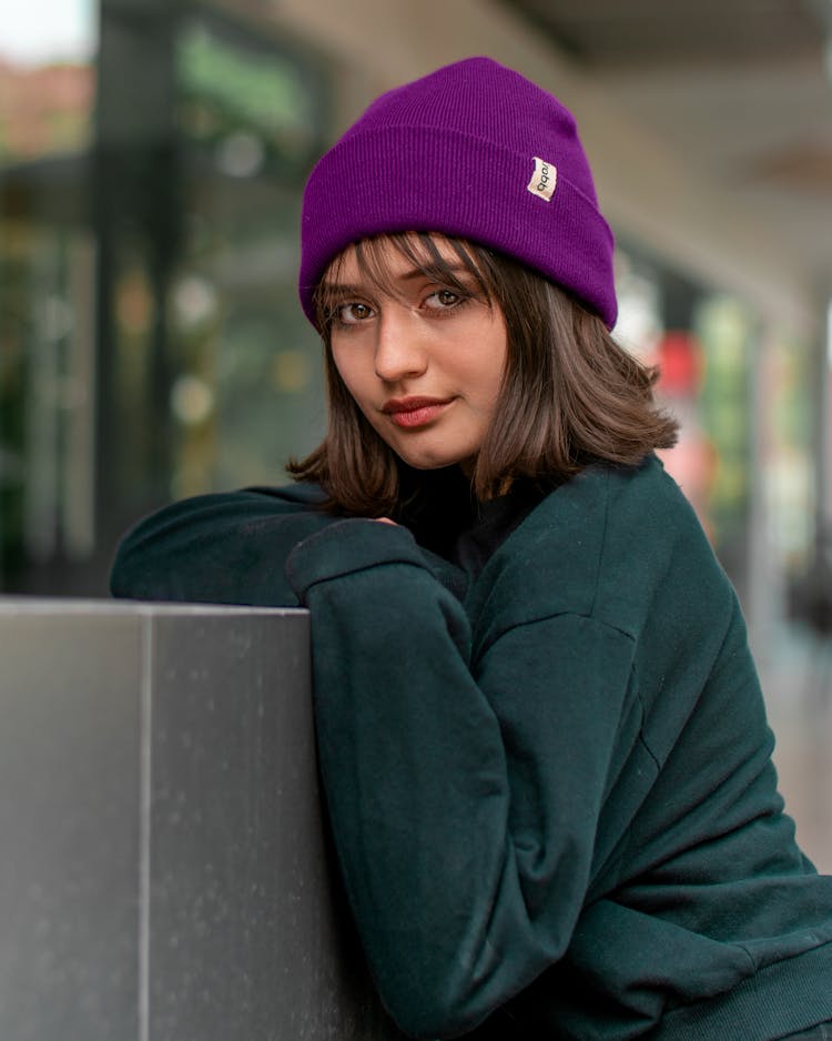 A Teenage Girl In A Black Jumper And A Purple Beanie Hat 