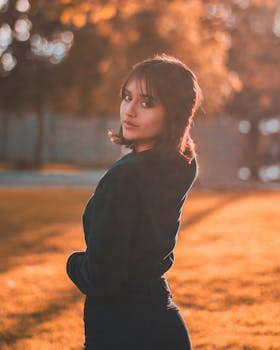 Stylish young woman in pullover poses outdoors in autumn light, Pitalito, Colombia.