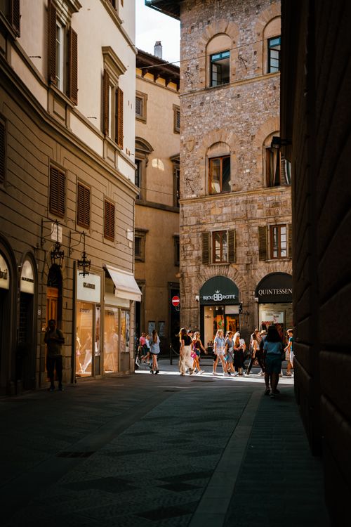 Free Charming alley in Florence, Italy featuring historic buildings and bustling street life. Stock Photo