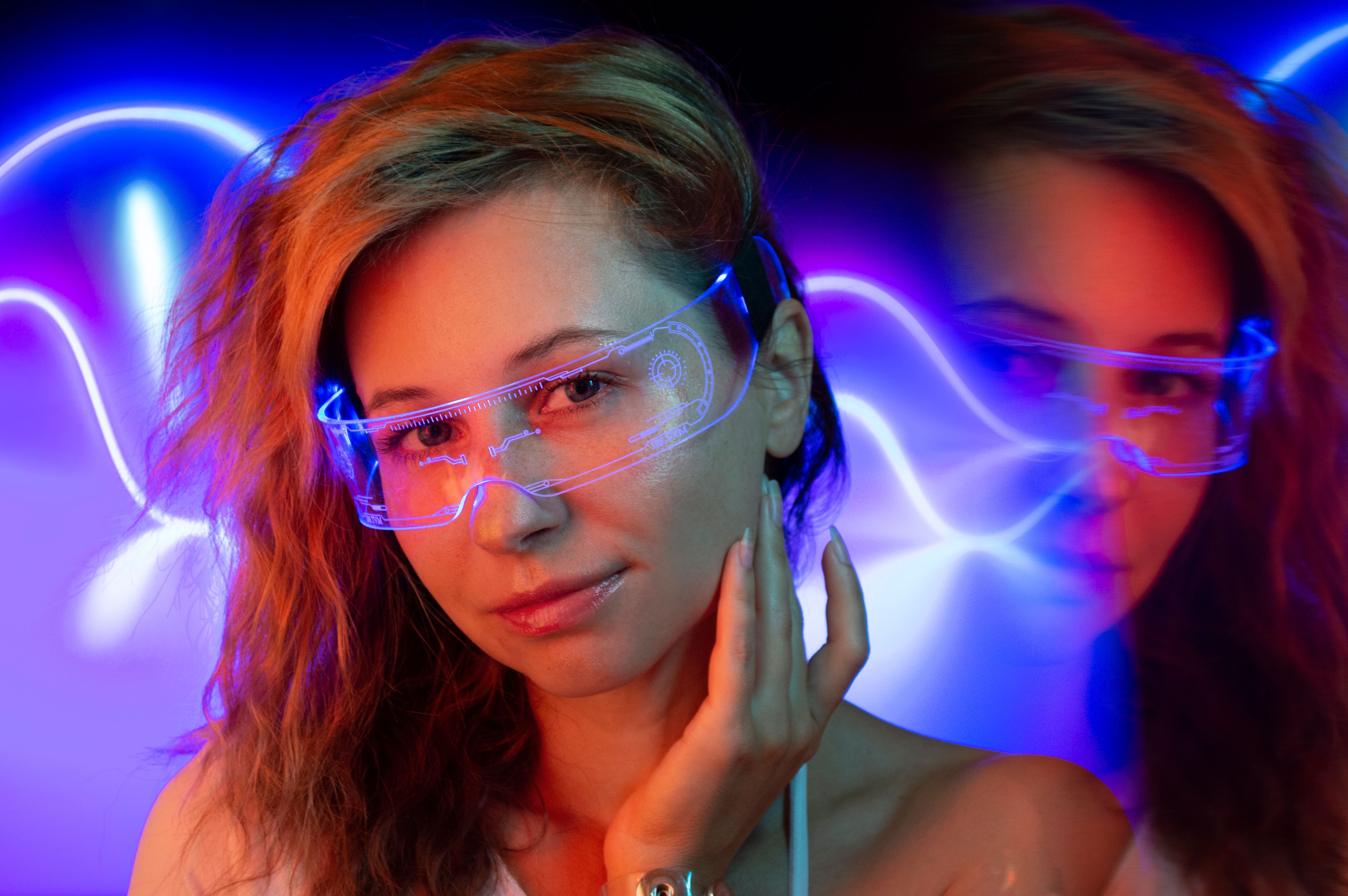 Mulher usando óculos tecnológicos transparentes em um ambiente iluminado por luzes coloridas
