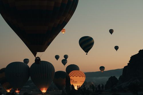 Free Breathtaking scene of hot air balloons rising at sunrise over Cappadocia's landscape. Stock Photo