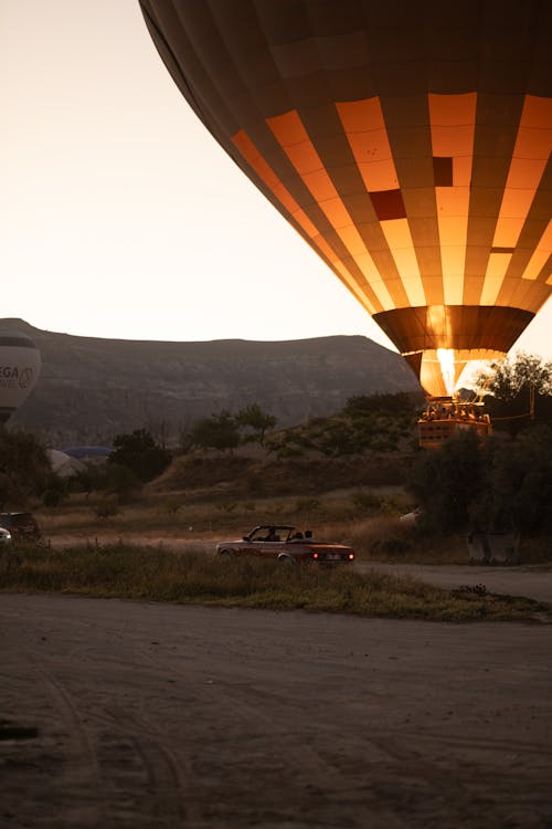 Moving Car Near Hot-Air Balloon on an Open Field