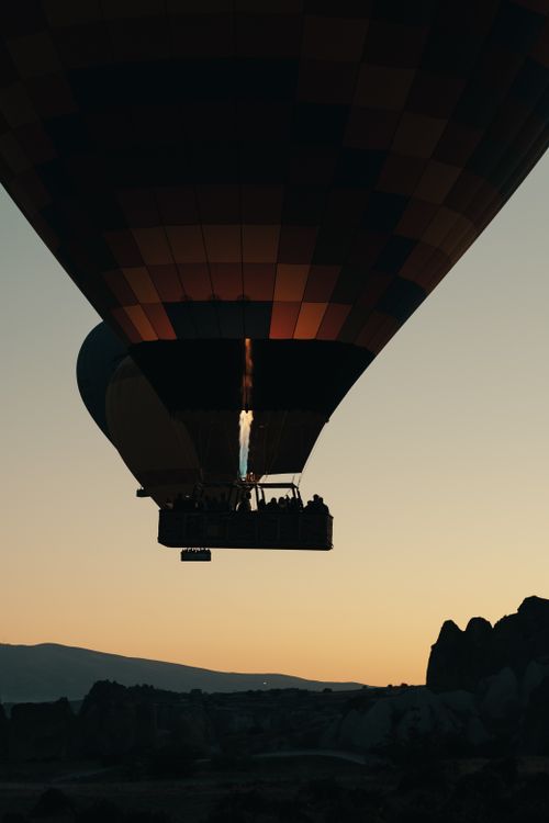 Free A hot air balloon soaring at sunrise over a picturesque valley, capturing the essence of adventure and travel. Stock Photo
