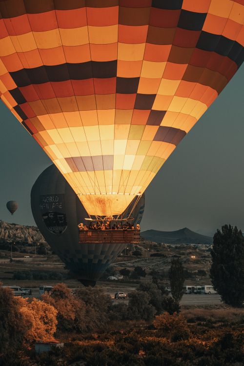 Free Colorful hot air balloon soaring over Cappadocia's unique landscape during a serene night. Stock Photo