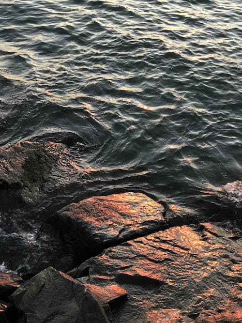 Brown Rock Formation on Body of Water