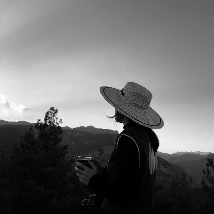 Black And White Photo Of A Woman Looking At A View And Holding A Camera 