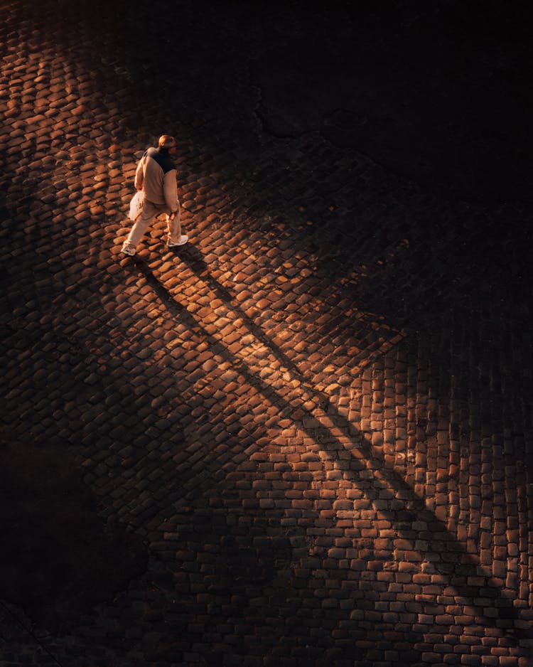 Man Walking On Cobblestones