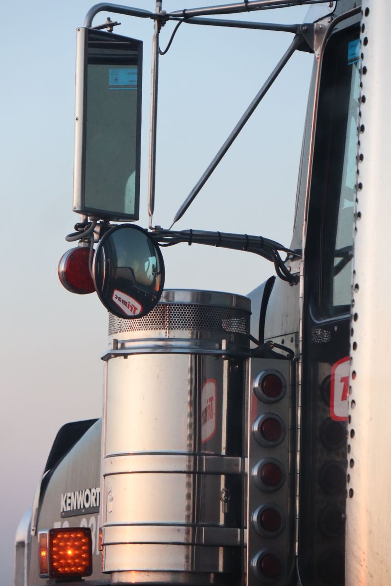 Detailed view of a stainless steel truck with side mirrors and signal lights