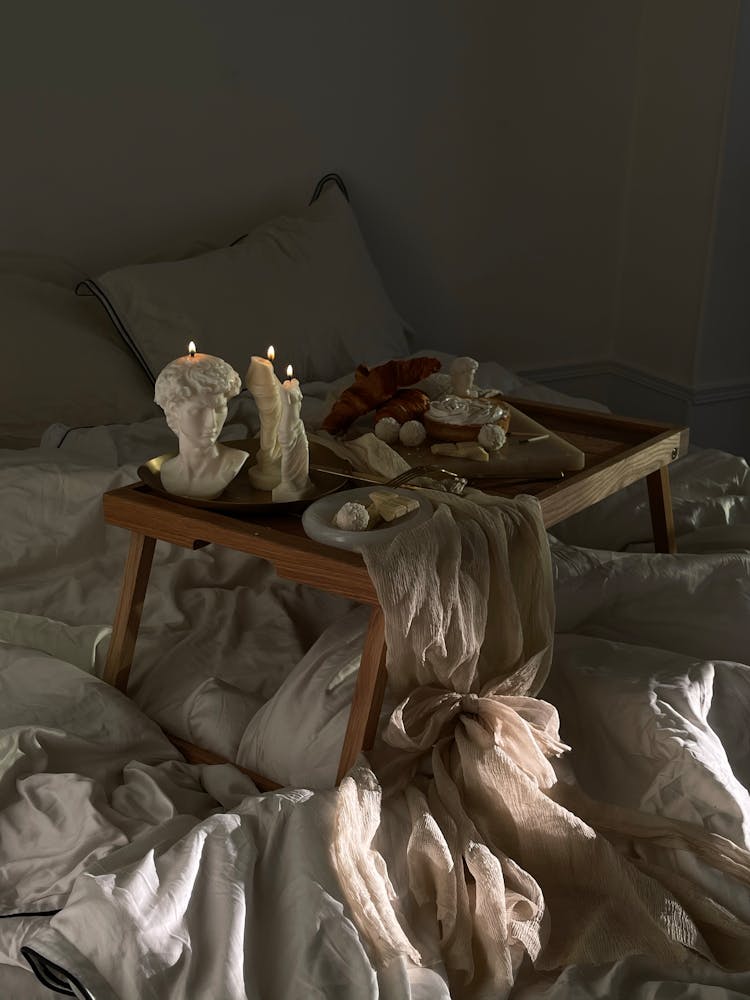 Wooden Tray With Breakfast And Candles In White Bed