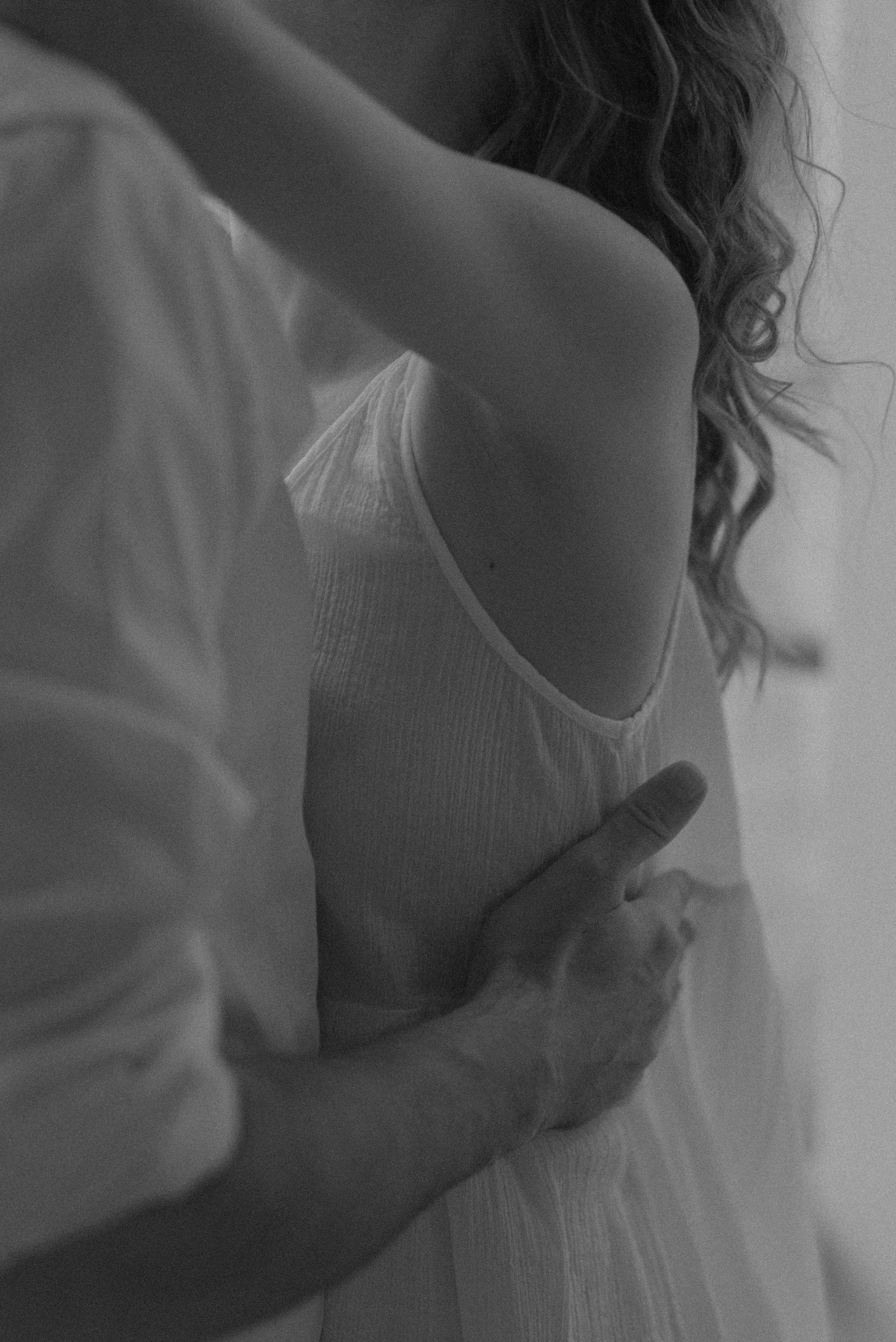 Intimate black and white photo of a couple embracing softly.