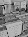 Grayscale Photo of Various Books