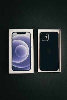 High-angle photo of a new smartphone and box on a black surface, showcasing sleek design.