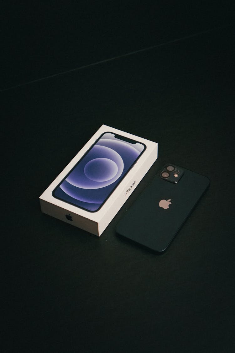 Black Apple Smartphone Beside A Box On A Black Surface