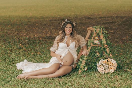 Woman in White Dress Sitting on Green Grass Field