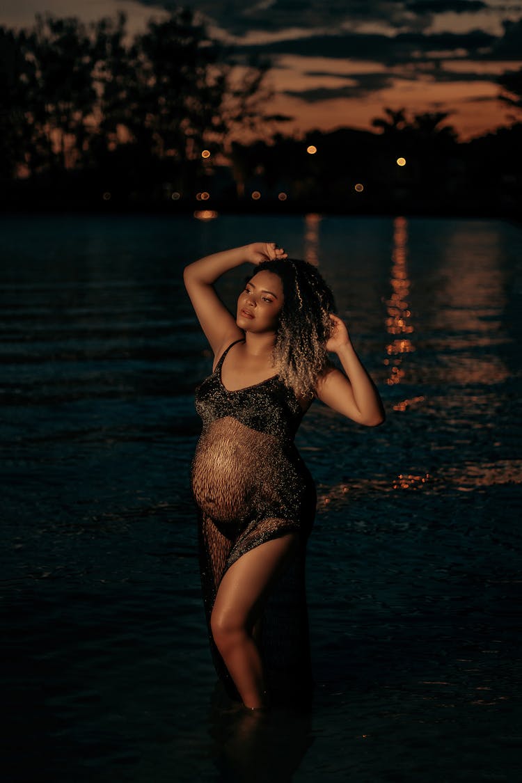 A Pregnant Woman In A Sheer Dress At A Shore