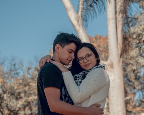 Free A young couple embraces lovingly outdoors in a sunny São Paulo park. Stock Photo