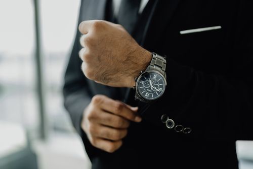 Free Close-up of a businessman adjusting his elegant wristwatch, showcasing luxury and style. Stock Photo
