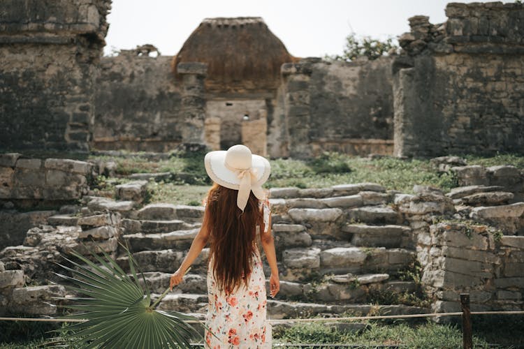 Back View Of A Woman Holding A Palm Leaf