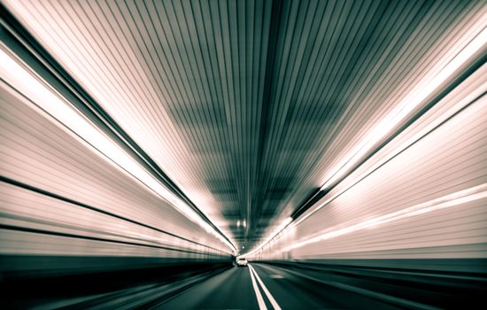 Speeding through a futuristic tunnel with blurred lines conveying movement and velocity.