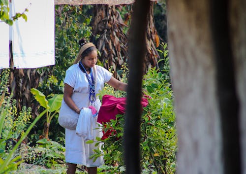 A Woman Drying Clothes on Plants