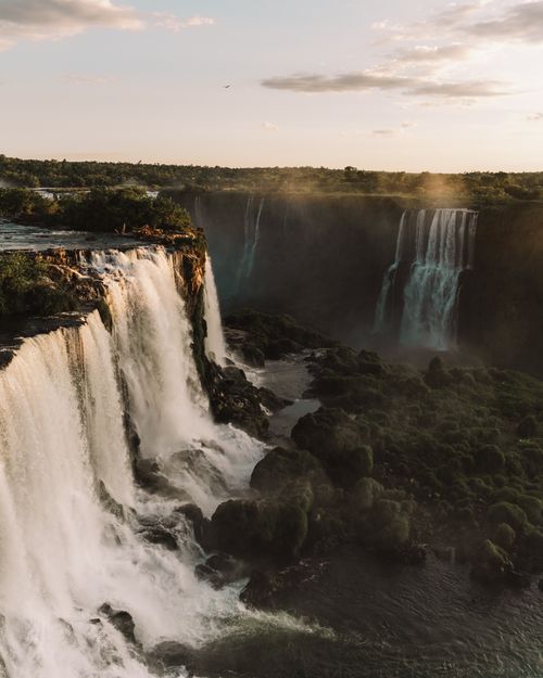 Free Majestic sunset over the cascading waters of Iguazu Falls, showcasing nature's power and beauty. Stock Photo