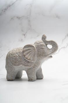 Intricate elephant sculpture with marble-like texture, perfect for decor and design enthusiasts.