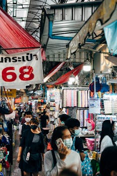 Vibrant scene of people shopping at a bustling Bangkok street market, showcasing local commerce.