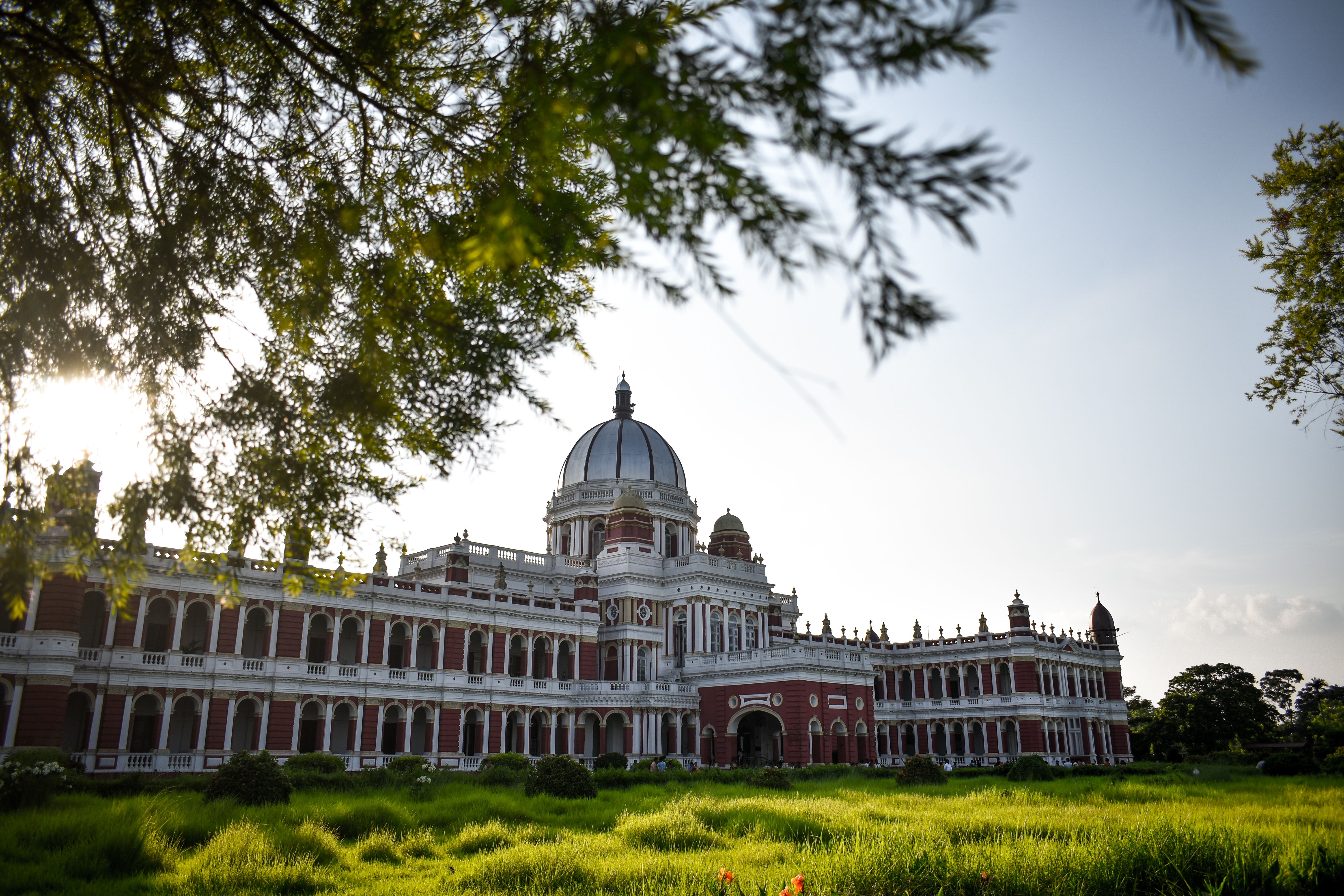 Stunning view of Cooch Behar Palace with lush greenery and clear skies in India.
