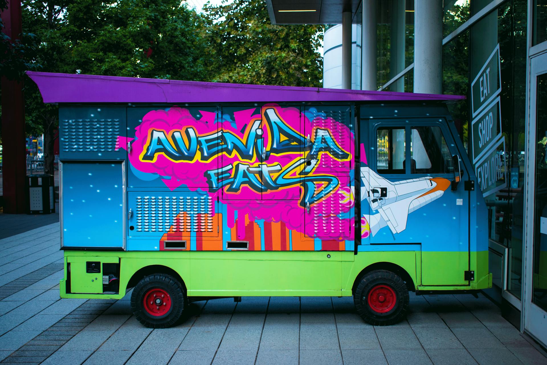 Vibrant graffiti food truck parked on a Houston street corner, showcasing urban art.