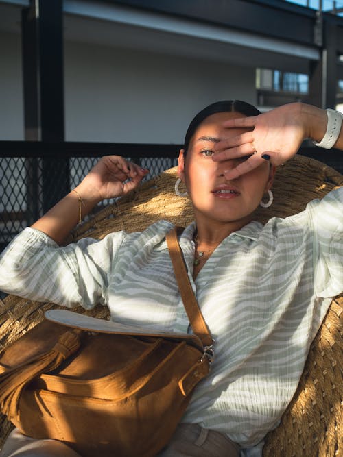 Woman Sitting in Sunlight, wearing Jewelry