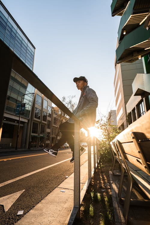 A Man in a Denim Jacket Sitting on a Railing