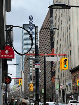 Urban street view of Yonge Street in Toronto featuring skyscrapers, traffic lights, and city life.