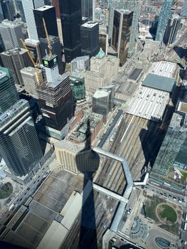 Stunning aerial shot of Toronto's skyline featuring CN Tower's shadow on urban landscape.