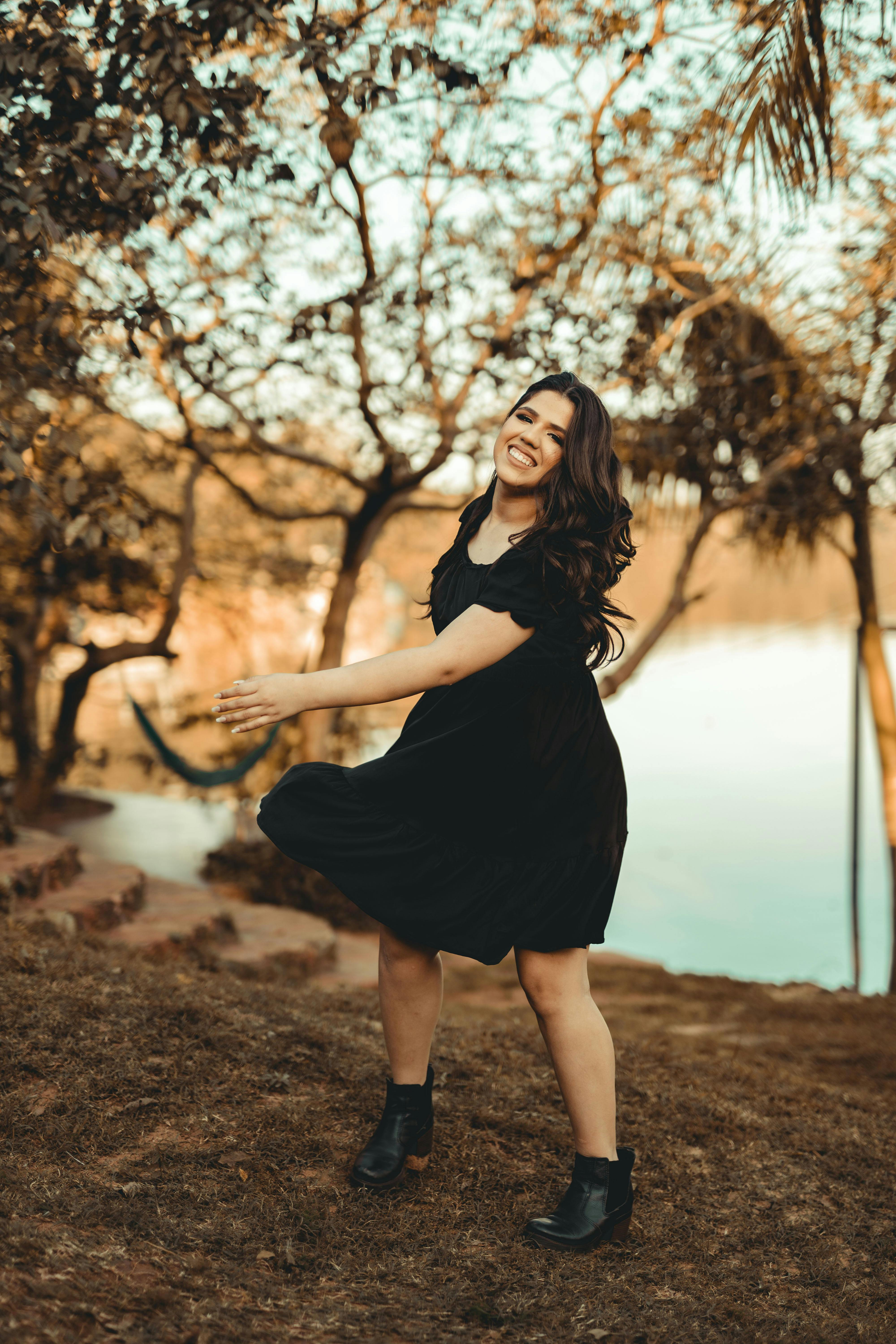 A Happy Woman Wearing a Black Dress and Black Boots  Free Stock Photo