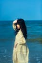 一位穿着黄色连衣裙的年轻女子在海边享受着宁静的夏日