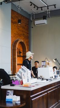 Busy café in Madiun, Indonesia with young baristas at work behind the counter.
