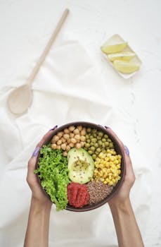 Delicious vegan bowl with avocado, chickpeas, corn, lettuce, and grains.