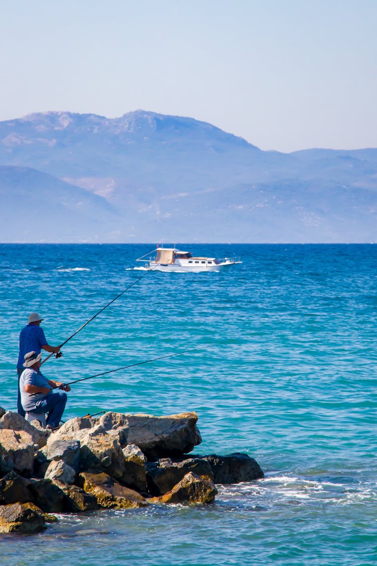 Men Fishing On A Rocky Shore