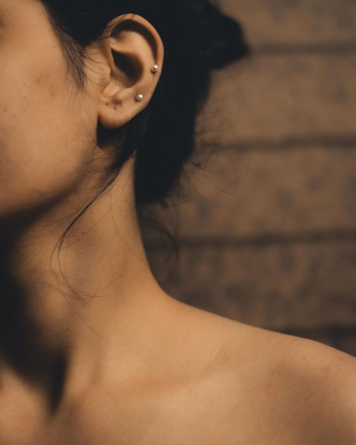Woman wearing multiple earrings in a close-up jewelry portrait
