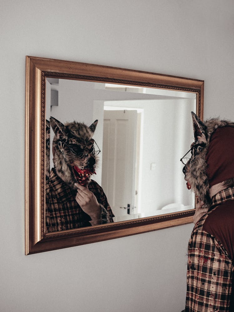 Man With A Realistic Wolf Mask Looking Into The Mirror 