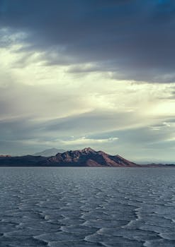 A breathtaking view of Bolivia's Salar de Uyuni salt flats and distant mountains under an expansive sky.