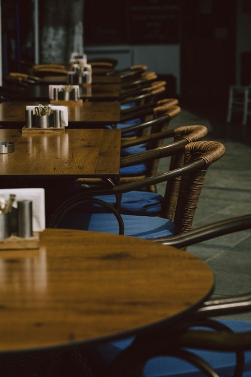 Free Wooden tables with blue-cushioned chairs in a cozy restaurant setting in Kaş, Antalya. Stock Photo