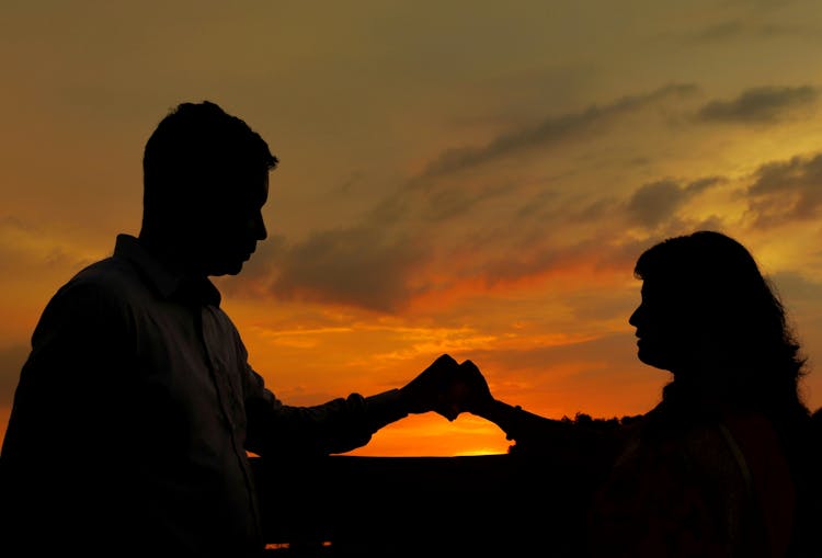 Couple Holding Hands At Sunset