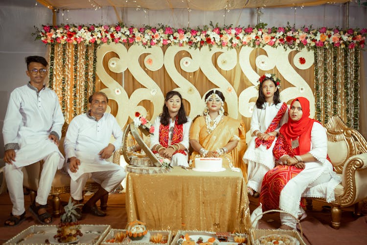 Family Posing By Decorated Table With Cake