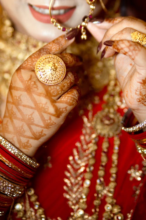 Close-up of a Bride with Henna Patterns on Her Hands and Wearing Traditional Clothing 