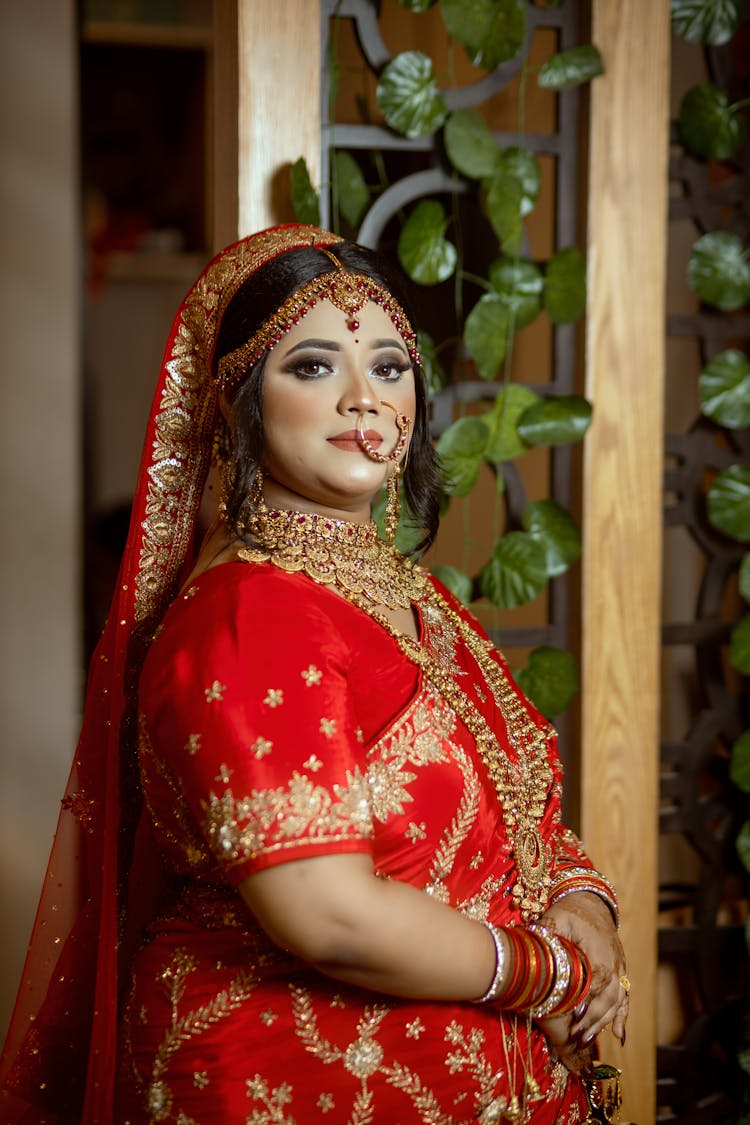 Woman Posing In A Decorative Red Dress And Traditional Golden Jewellery