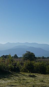 Peaceful countryside scene with mountains and clear sky, perfect for nature lovers.