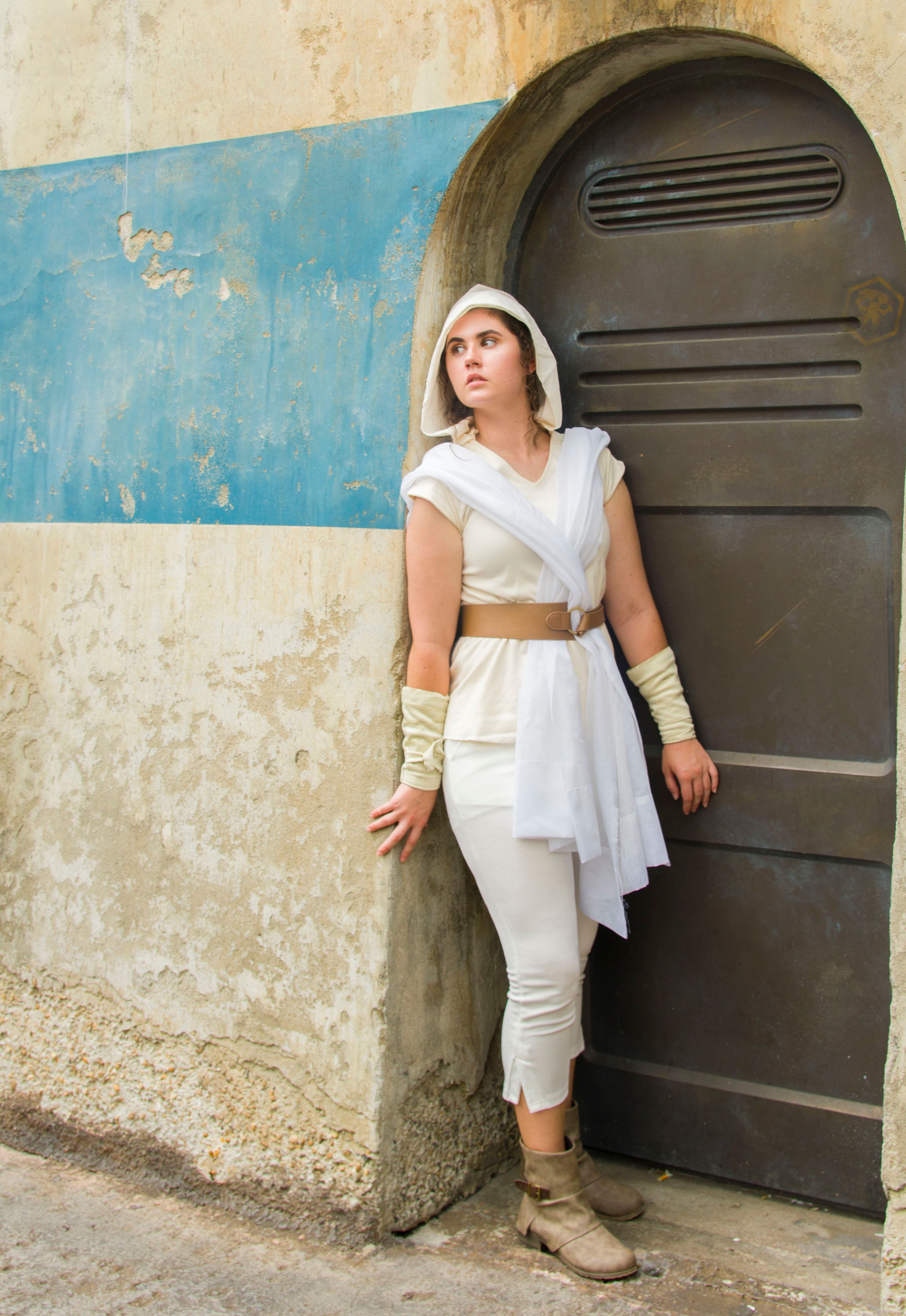 Young woman dressed as a Star Wars character posing against a rustic backdrop.