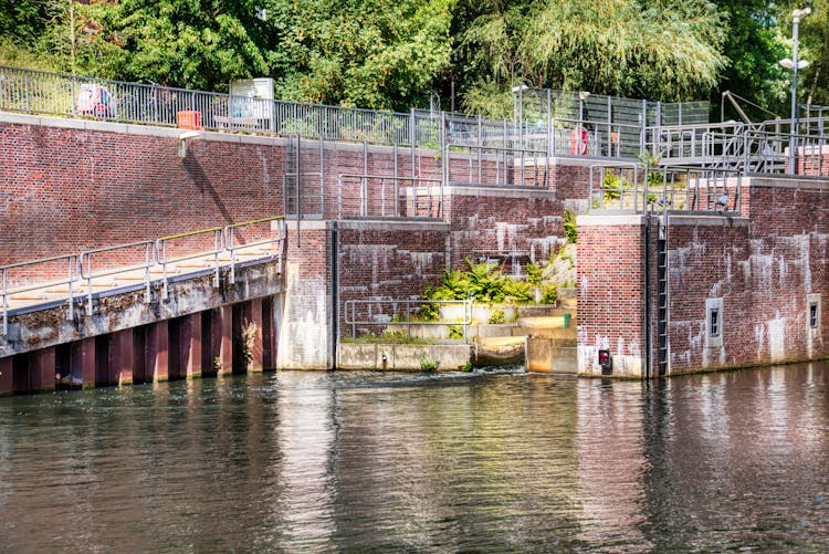 Brick Walls Of Dam On River